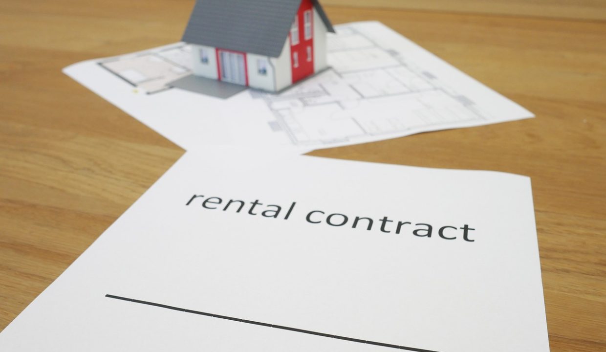 casetta in miniatura su foglio di contratto di affitto 4+4