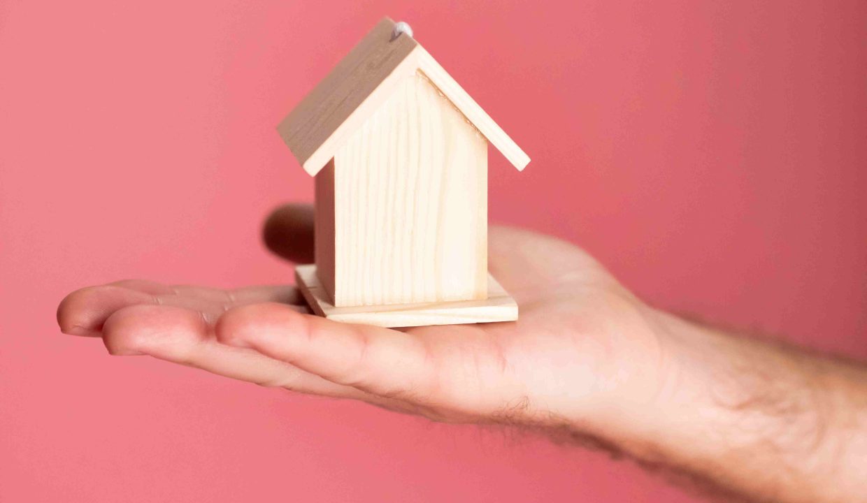 mano che tiene casetta di legno per rappresentare nuda proprietà